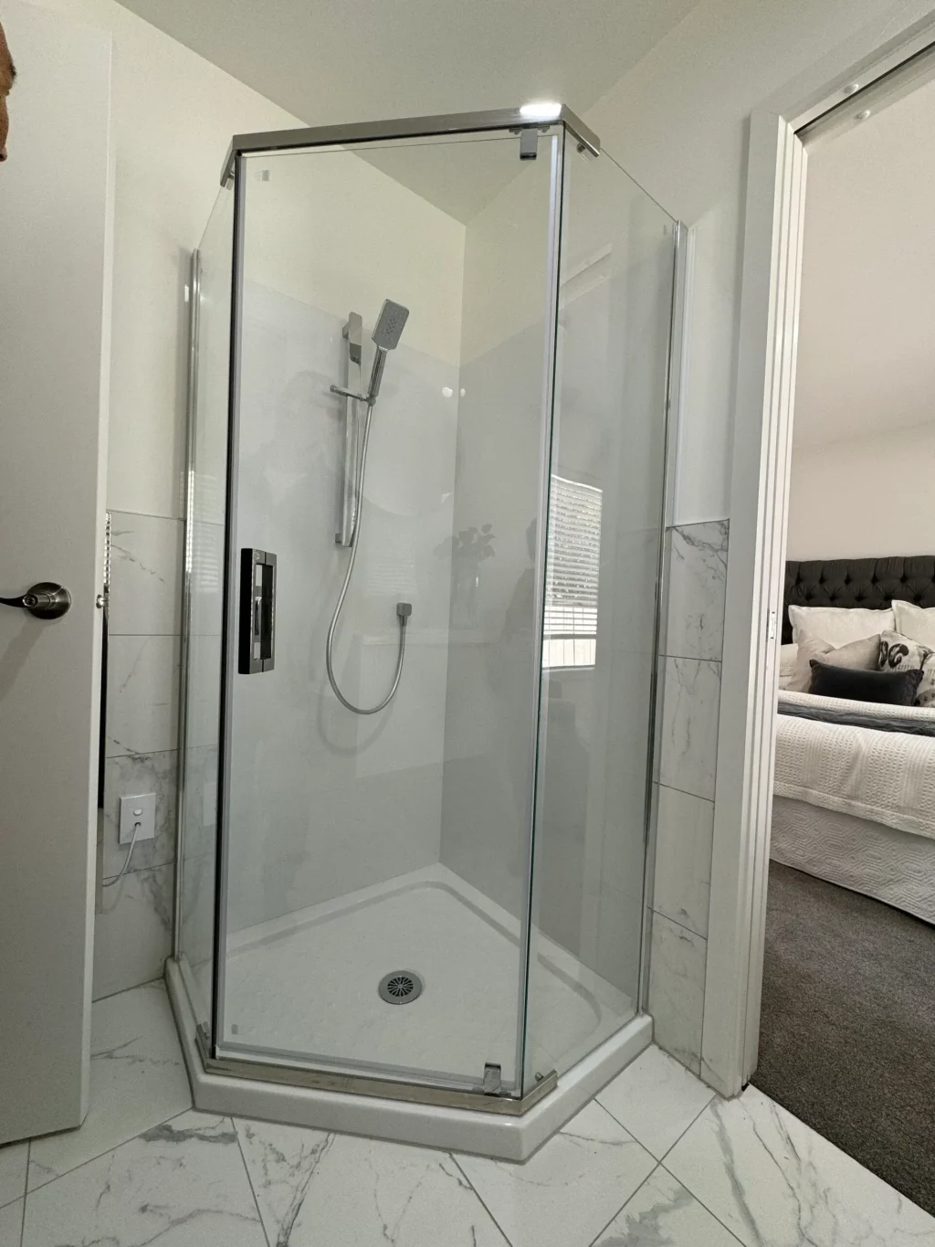 Glass shower enclosure with modern fixtures in a bathroom.
