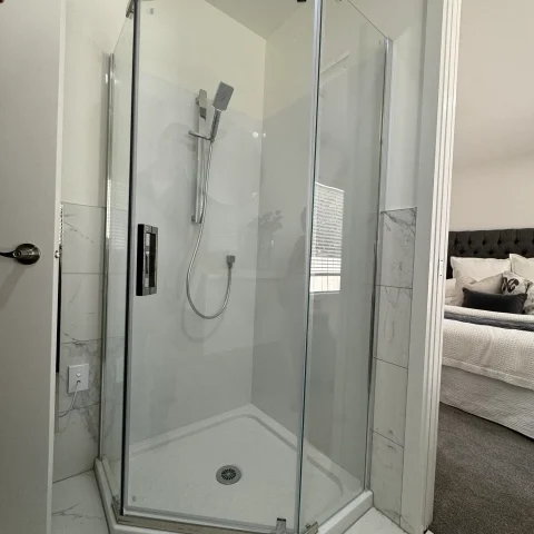 Glass shower enclosure with modern fixtures in a bathroom.