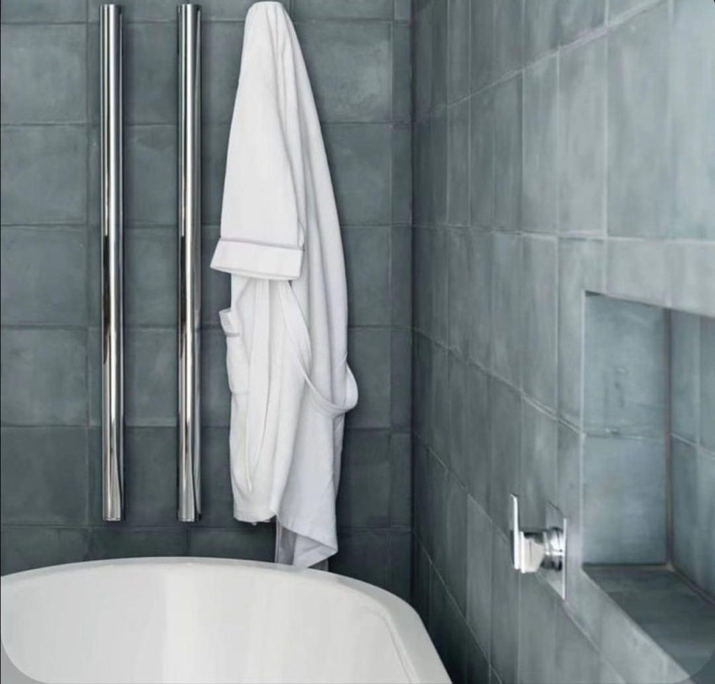White towel hanging in a modern bathroom with gray tiles.