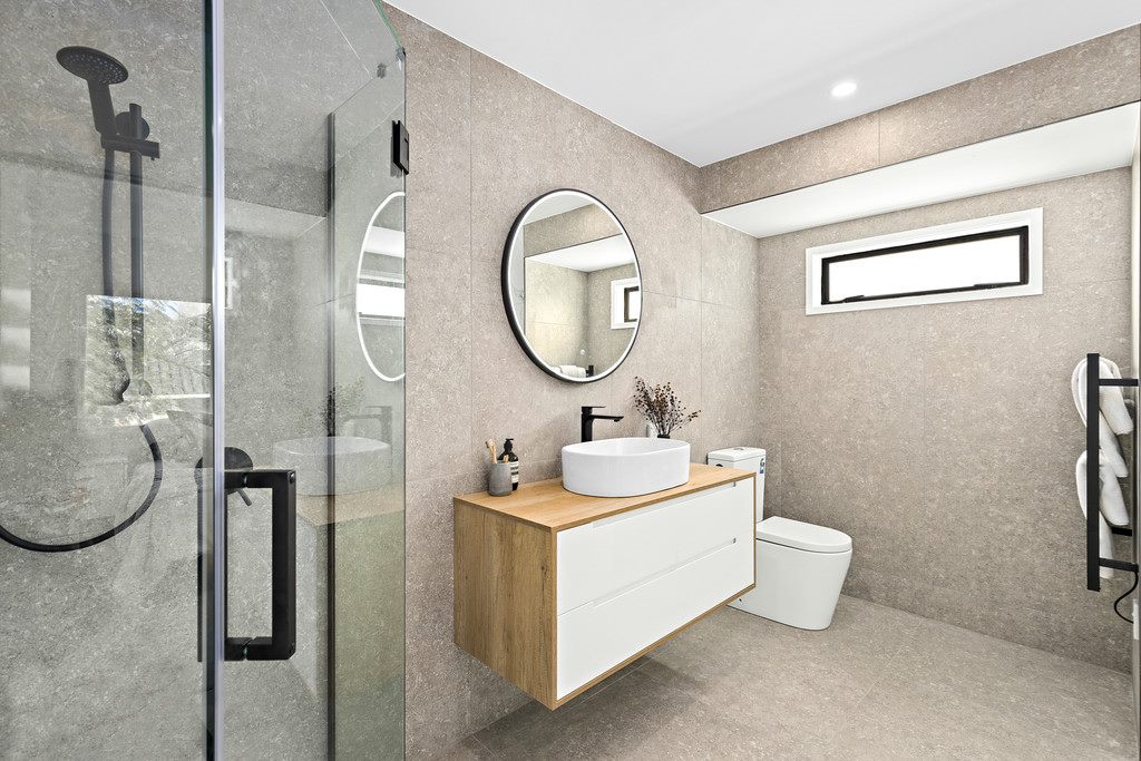 A bathroom with an LED mirror, sink, bathtub, and toilet