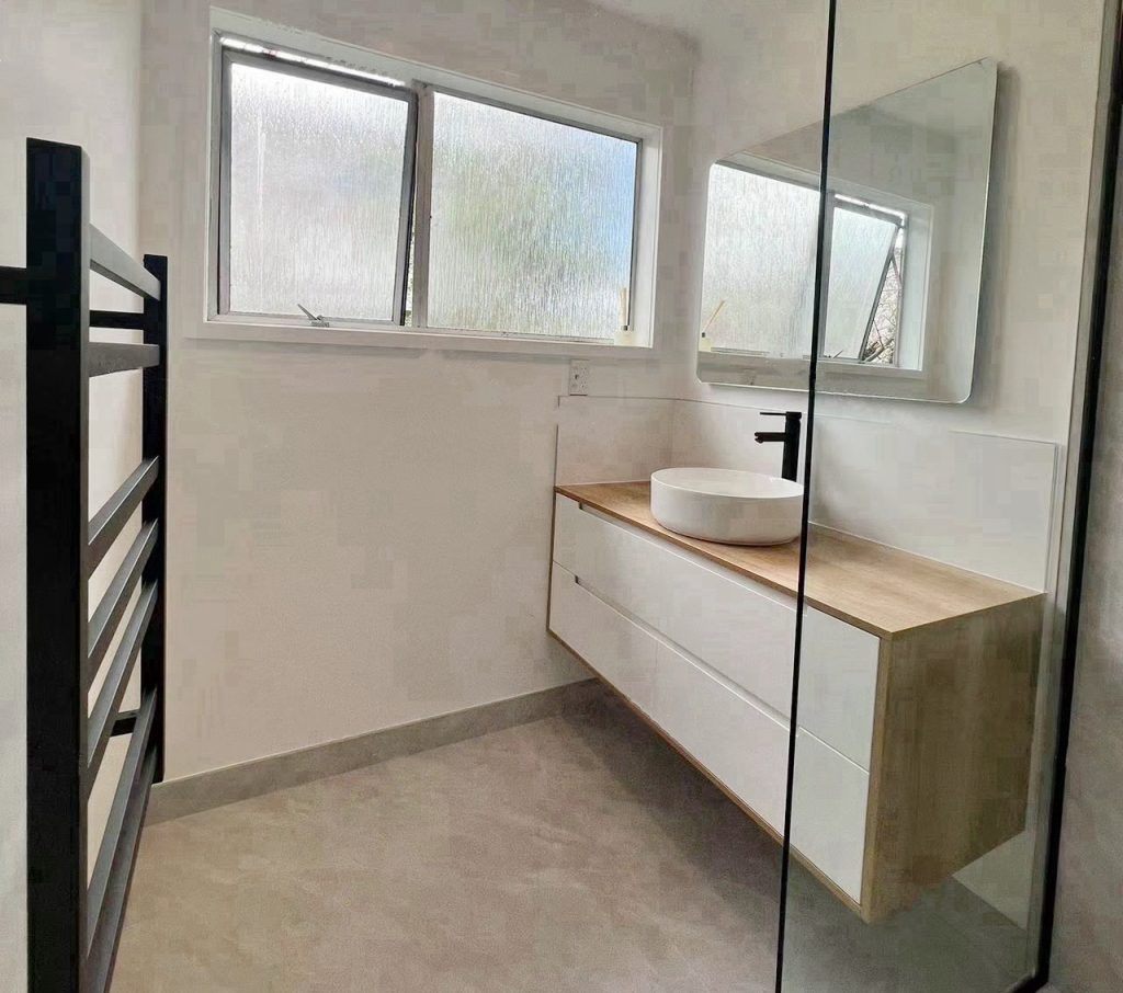 Modern bathroom with sink, mirror, and frosted windows.
