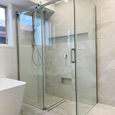 Modern bathroom with glass shower enclosure and freestanding bathtub.