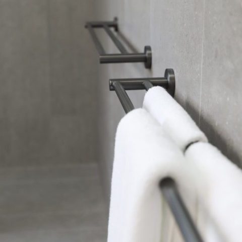 White towel hanging on a modern black towel rack.