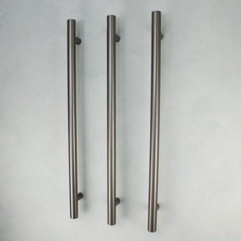 Three vertical metal door handles on a light background.