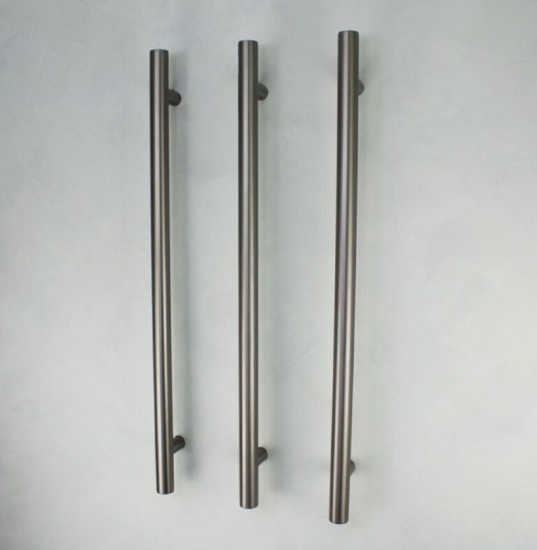 Three vertical metal door handles on a light background.