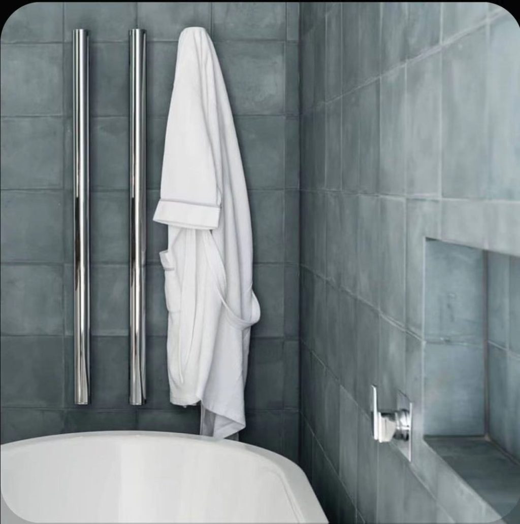 White towel hanging in a modern bathroom with gray tiles.
