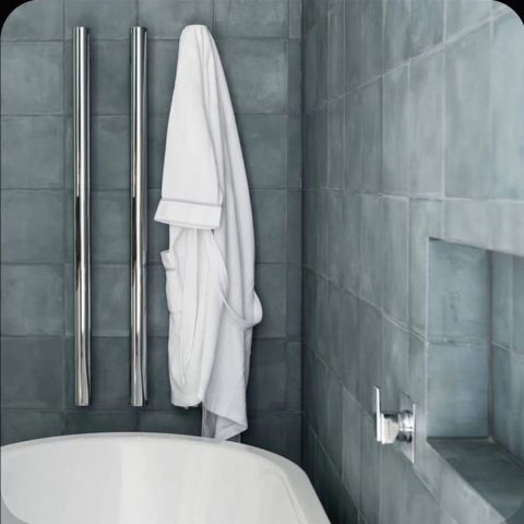 White towel hanging in a modern bathroom with gray tiles.