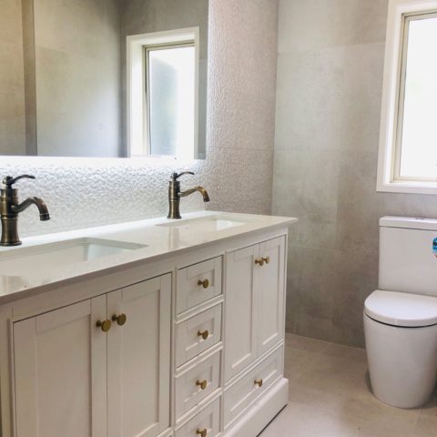 white vanity top with one rectangular mirror on the wall