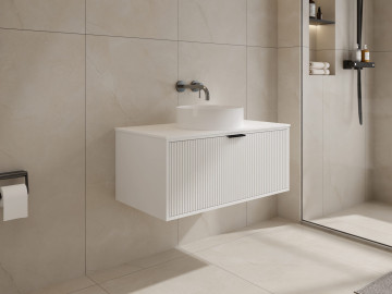 Modern white bathroom vanity with wall-mounted faucet and mirror.