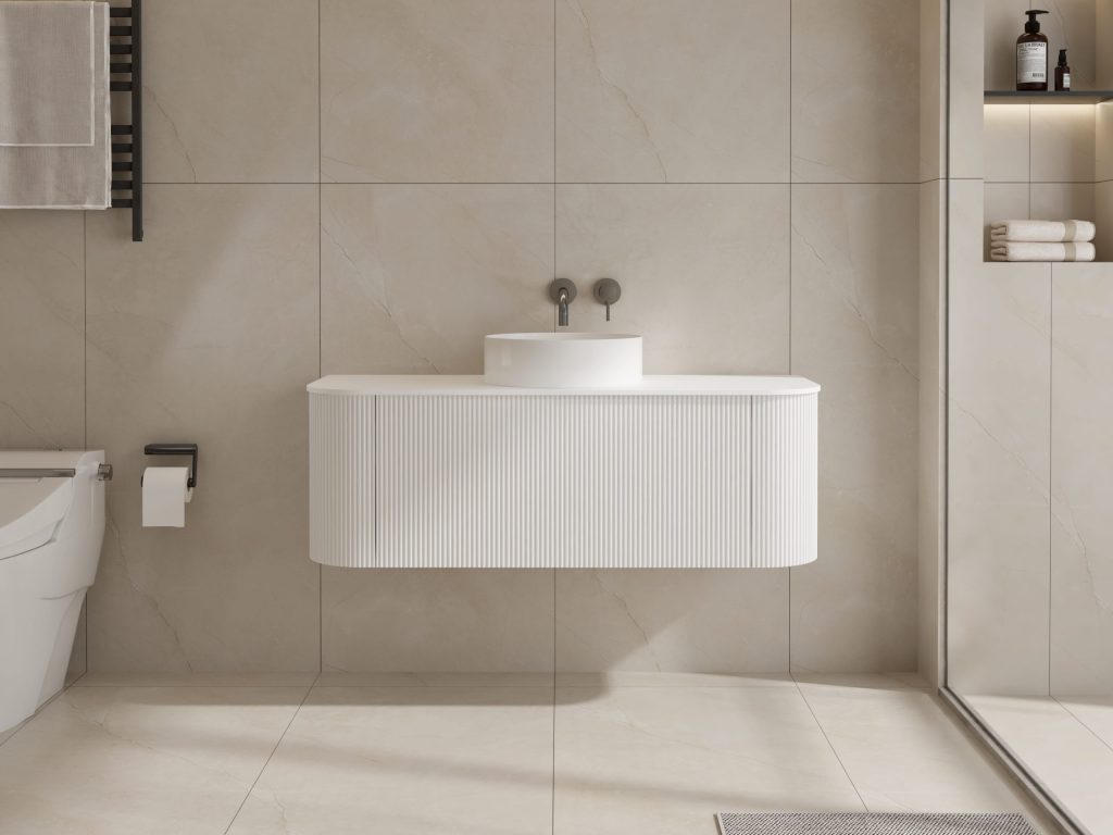 Modern white bathroom sink with wall-mounted faucet and beige tiles.