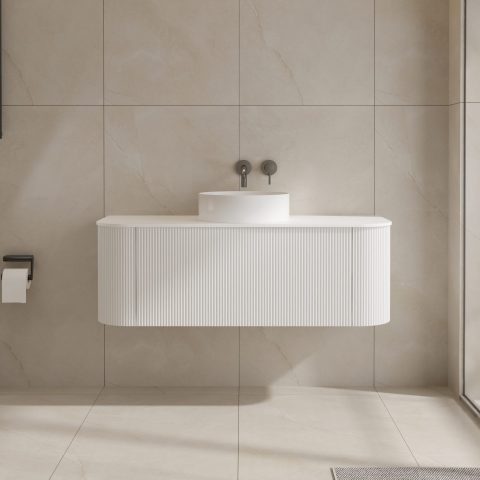 Modern white bathroom sink with wall-mounted faucet and beige tiles.