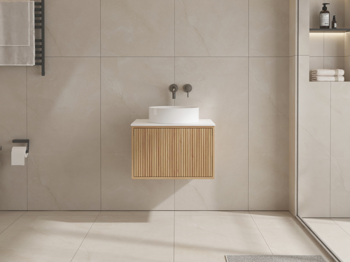 Modern bathroom with wooden vanity and round white sink against tiled wall.