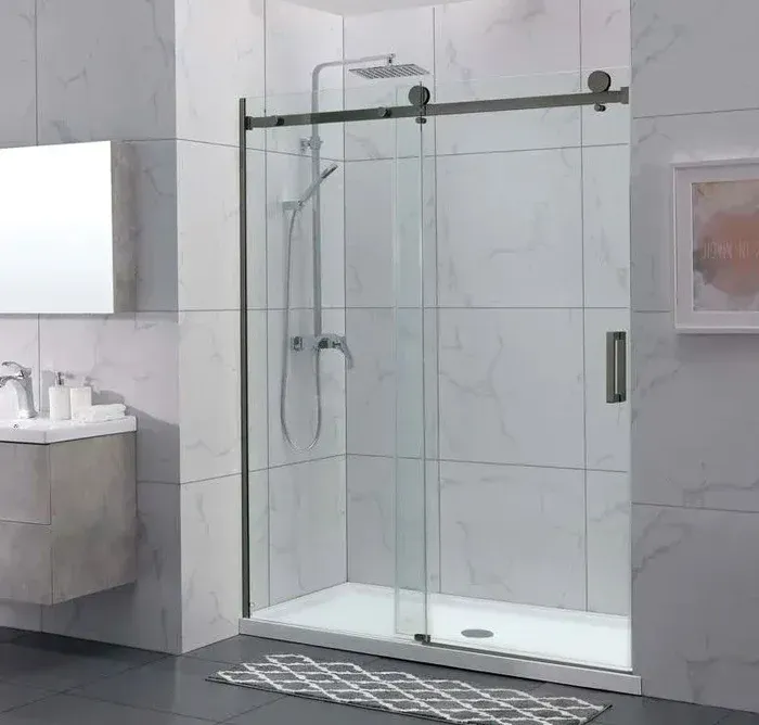Modern glass shower with sliding door in a marble-tiled bathroom.